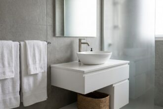 Meuble vasque blanc suspendu avec tiroirs dans une petite salle de bain moderne en carrelage gris